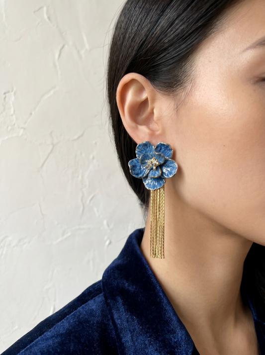 Side profile of a model wearing HECROWN blue flower tassel earrings. The handmade jewelry showcases the sculptural elegance of Jingdezhen porcelain and the fluid movement of gold chain tassels.
