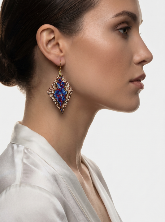 Side profile of a model wearing HECROWN 005 handcrafted rhombus ceramic earrings. The vibrant blue and red glaze contrast with a textured bronze surface, showcasing the sculptural scale and artistic presence of Jingdezhen jewelry.