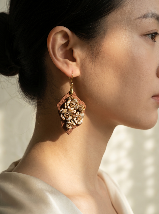 Side profile of a model wearing HECROWN 007 floral ceramic earrings. The natural sunlight highlights the intricate porcelain rose details and the earthy clay texture.
