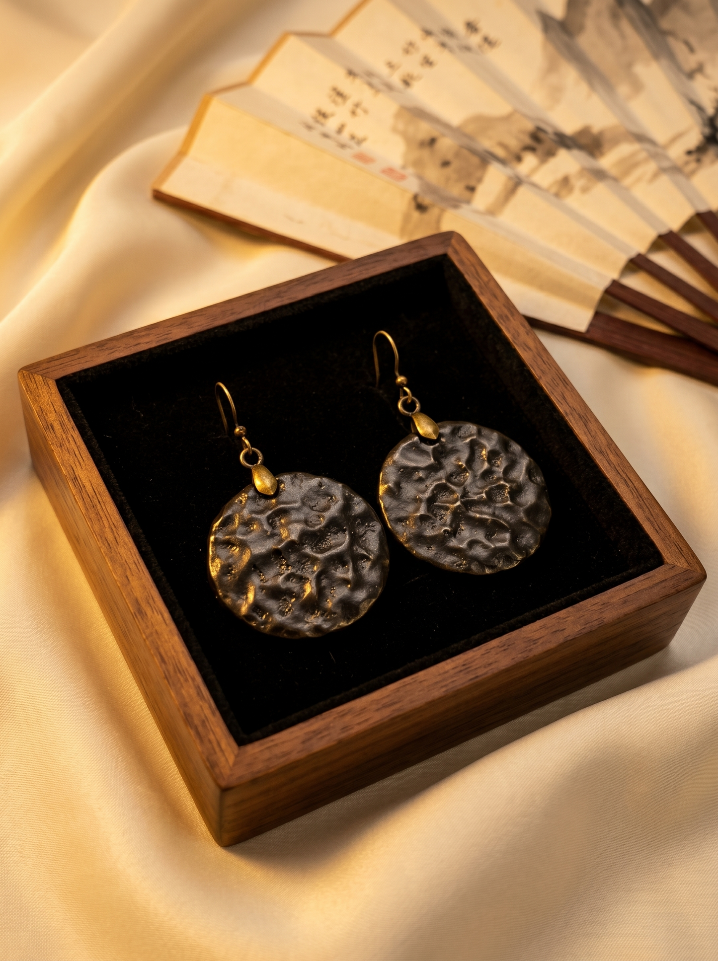 HECROWN 014 series round black hammered ceramic earrings presented in a premium wooden box with silk and folding fans. Showcasing the vintage Oriental aesthetic of sincere Jingdezhen handmade jewelry.
