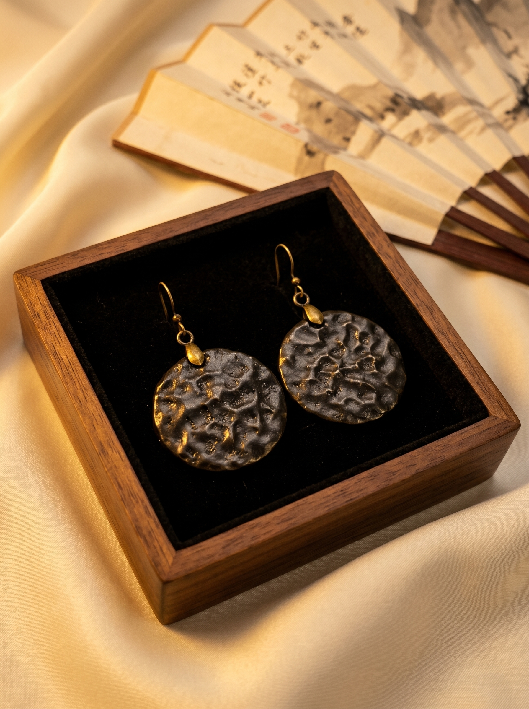 HECROWN 014 series round black hammered ceramic earrings presented in a premium wooden box with silk and folding fans. Showcasing the vintage Oriental aesthetic of sincere Jingdezhen handmade jewelry.