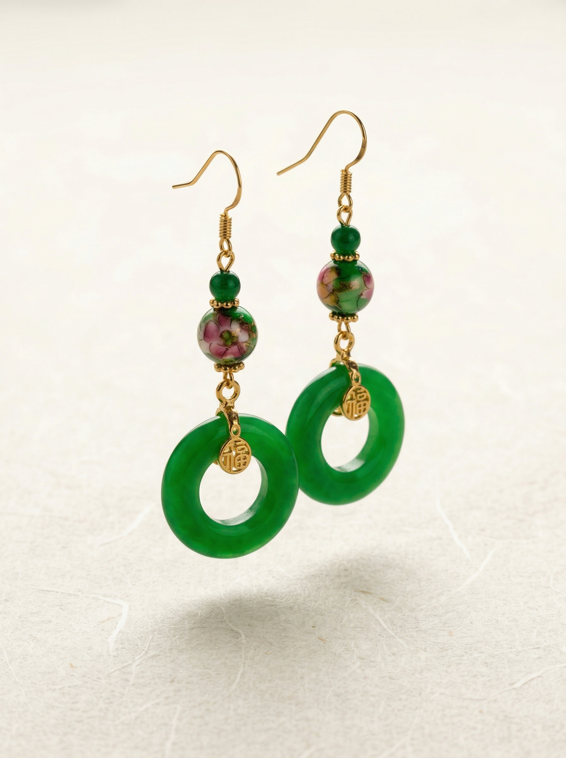 A pair of HECROWN green ceramic Pingan-kou earrings with hand-painted floral beads and gold 'Fu' charms. Authentic Jingdezhen handmade jewelry.