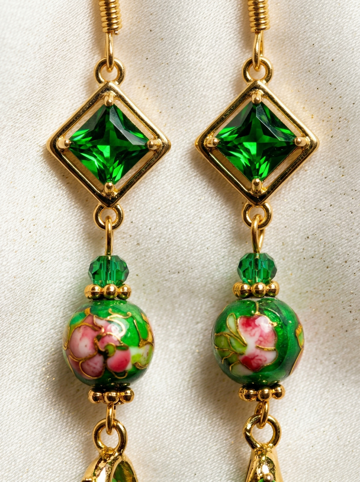 Extreme macro shot of HECROWN ceramic earrings, focusing on the hand-painted green floral bead and square emerald crystal. Authentic Jingdezhen craftsmanship.