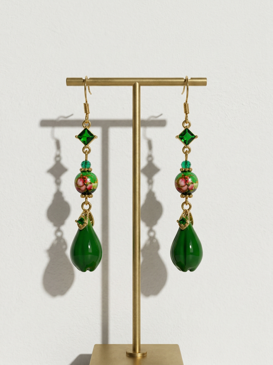 A pair of HECROWN 018 long emerald green ceramic teardrop earrings with floral beads and crystals on a gold stand. Sincere Jingdezhen handmade jewelry.