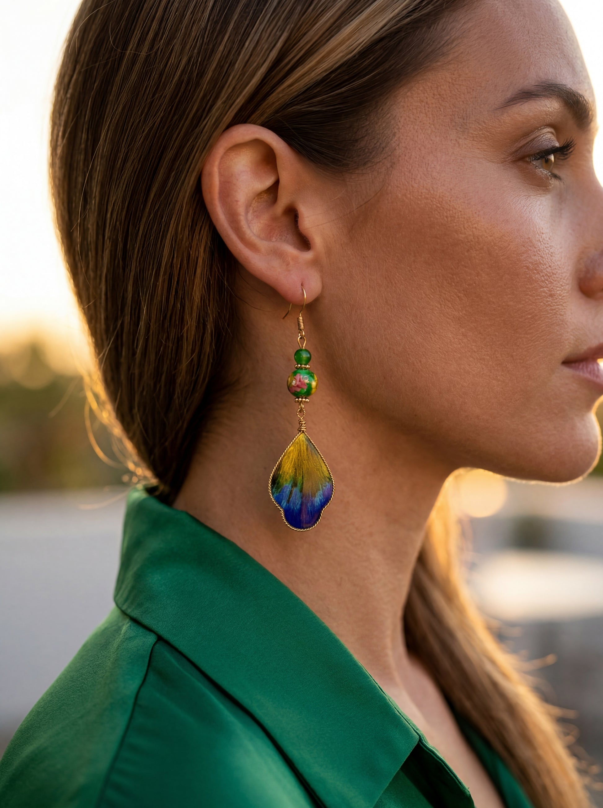 Side profile of a model wearing the HECROWN 019 silk and ceramic wing earrings. A bold, lightweight statement jewelry piece for special occasions.