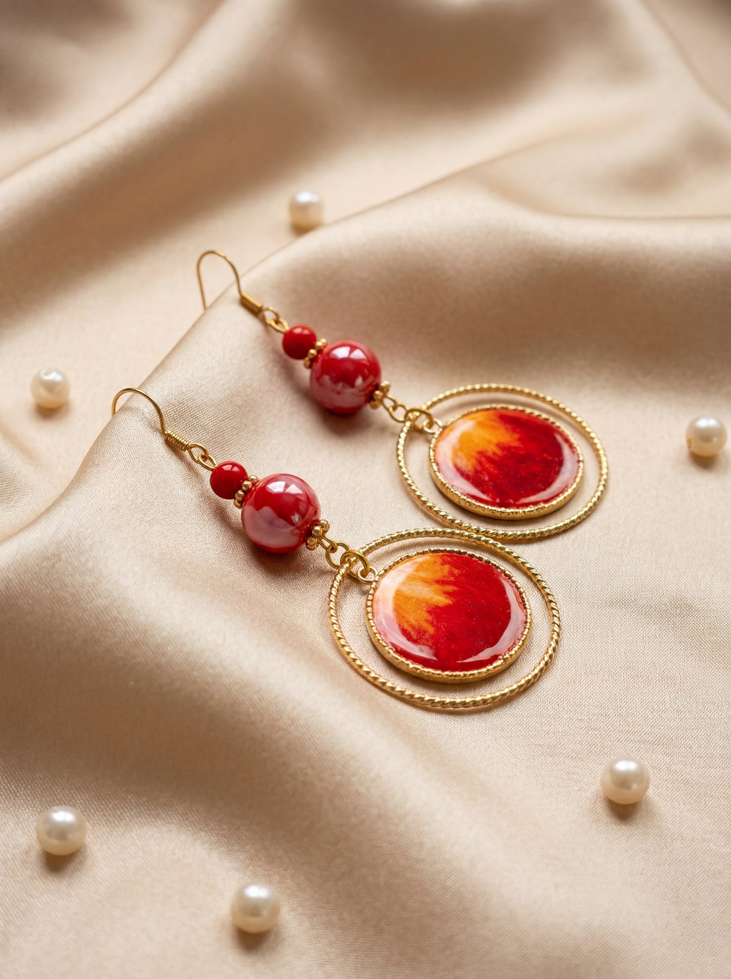 Fiery red HECROWN ceramic and silk earrings on champagne satin with pearls. A luxurious lifestyle shot perfect for a Valentine's Day gift for her.