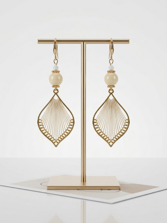 A pair of HECROWN 021 cream ceramic and silk weaving earrings on a gold T-stand. Minimalist Jingdezhen handmade jewelry.
