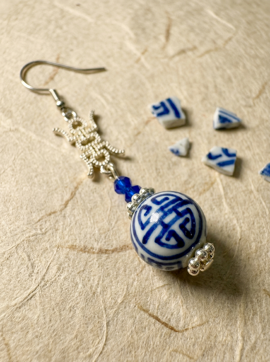 A pair of HECROWN 025 cobalt blue ceramic earrings in an irregular bloom bud shape with hand-painted dots. Sincere Jingdezhen handmade jewelry.