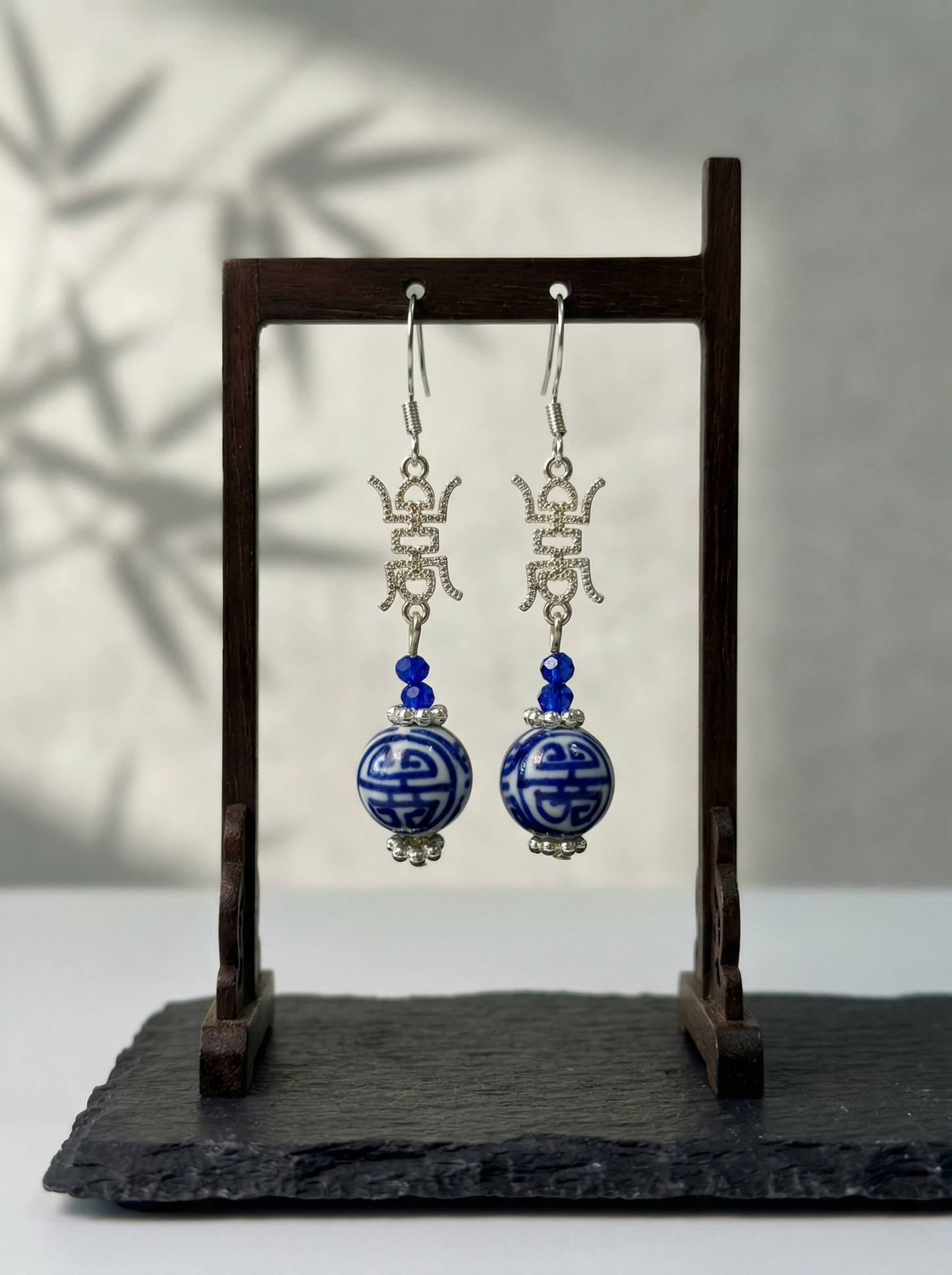 Extreme macro shot of HECROWN 3D ceramic earring, focusing on the dark cobalt glaze and the fine hand-painted white dots. Sincere artisan craftsmanship.