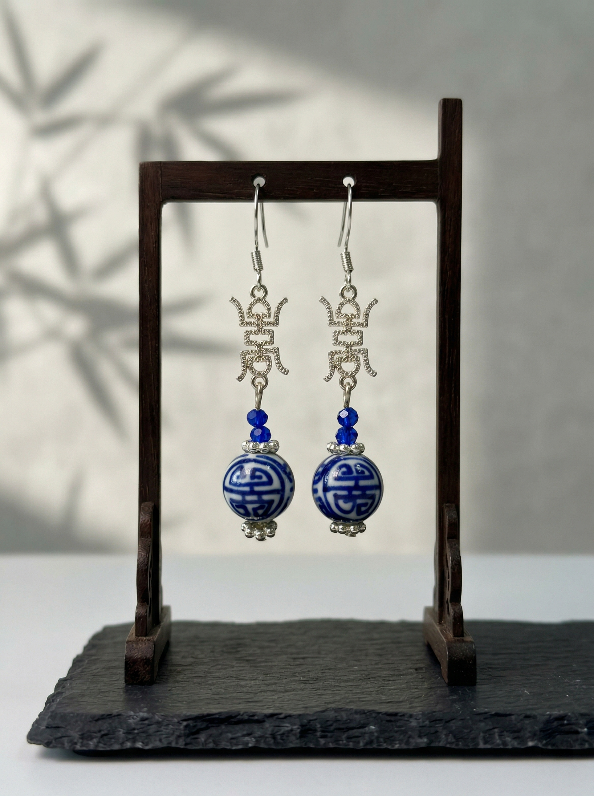 Extreme macro shot of HECROWN 3D ceramic earring, focusing on the dark cobalt glaze and the fine hand-painted white dots. Sincere artisan craftsmanship.