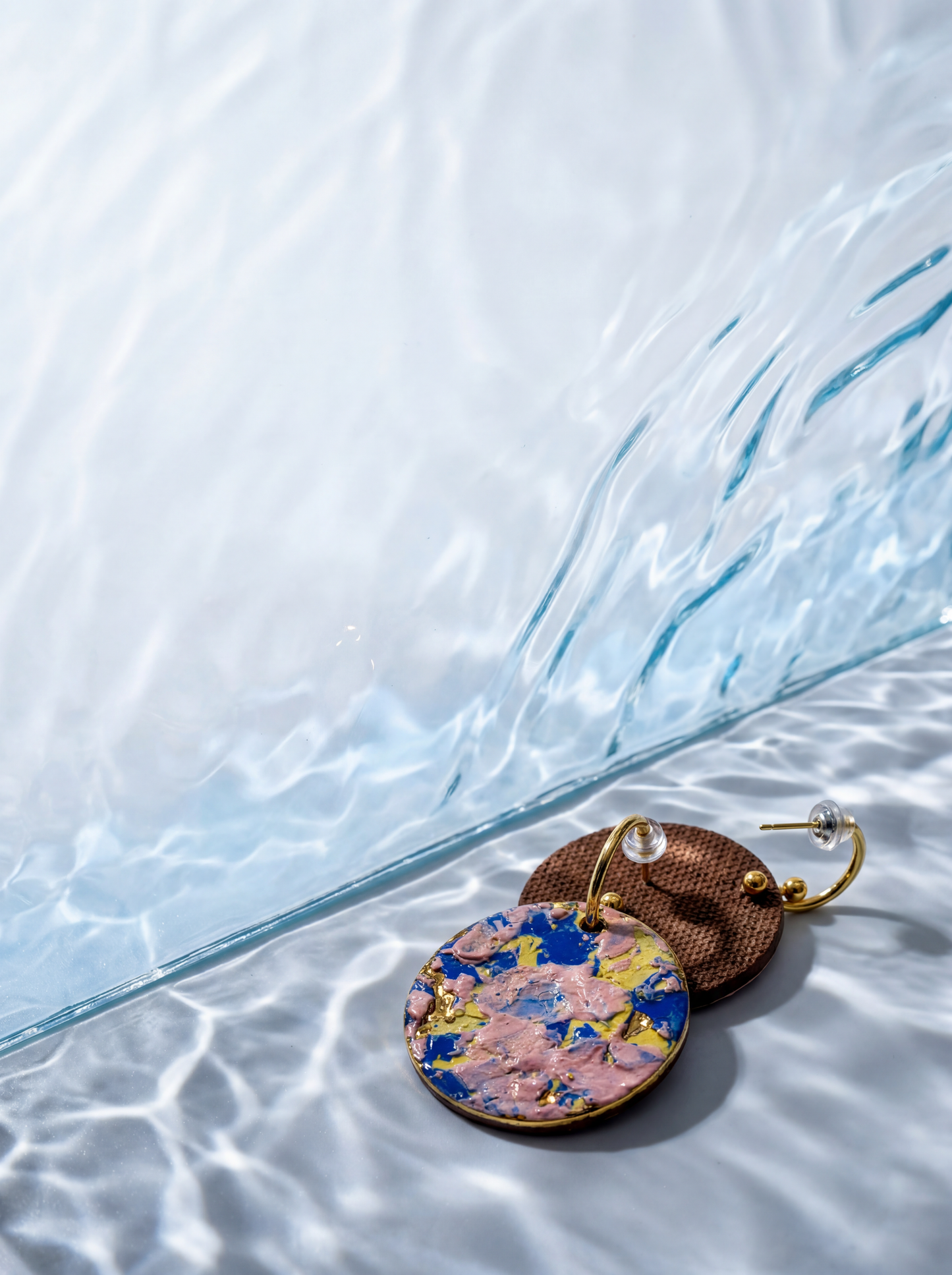 A single handmade ceramic earring with vibrant impasto glaze suspended in a neo-classical setting, featuring a vintage fireplace and oil painting. HECROWN 1-of-1 wearable art, showcasing the fusion of contemporary abstract expressionism and timeless classical elegance.