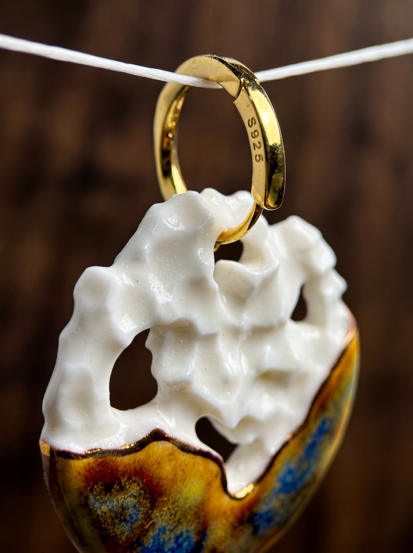 Extreme close-up of a handmade crater-textured ceramic earring showcasing a gold-plated S925 sterling silver hoop. HECROWN artisan jewelry detail shot revealing the sculptural thickness and metallic glaze transition, designed for hypoallergenic wear.