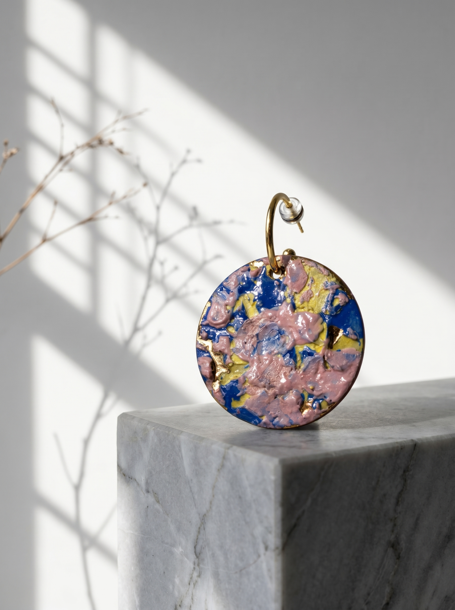 Artistic side profile of a model wearing round ceramic earrings with colorful impasto glaze. Soft, moody indoor lighting highlights the handcrafted texture. HECROWN signature wearable art from Jingdezhen, perfect for art-inspired fashion.