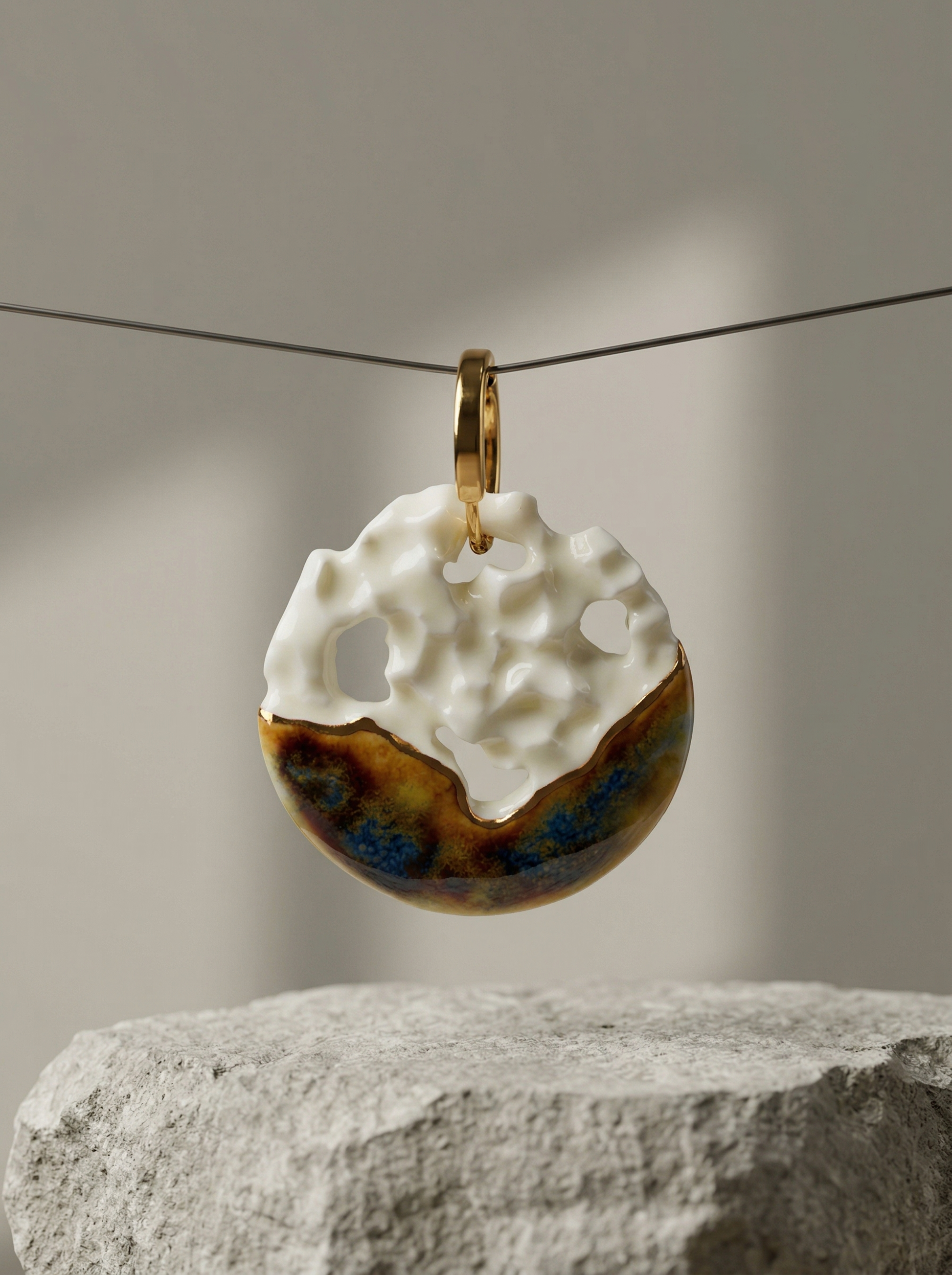A single handmade ceramic hoop earring featuring white crater-like cutouts and metallic glaze, suspended on a thin wire above a rough grey stone block. HECROWN 1-of-1 wearable art displayed in a minimalist gallery setting, highlighting its architectural design and raw material contrast.