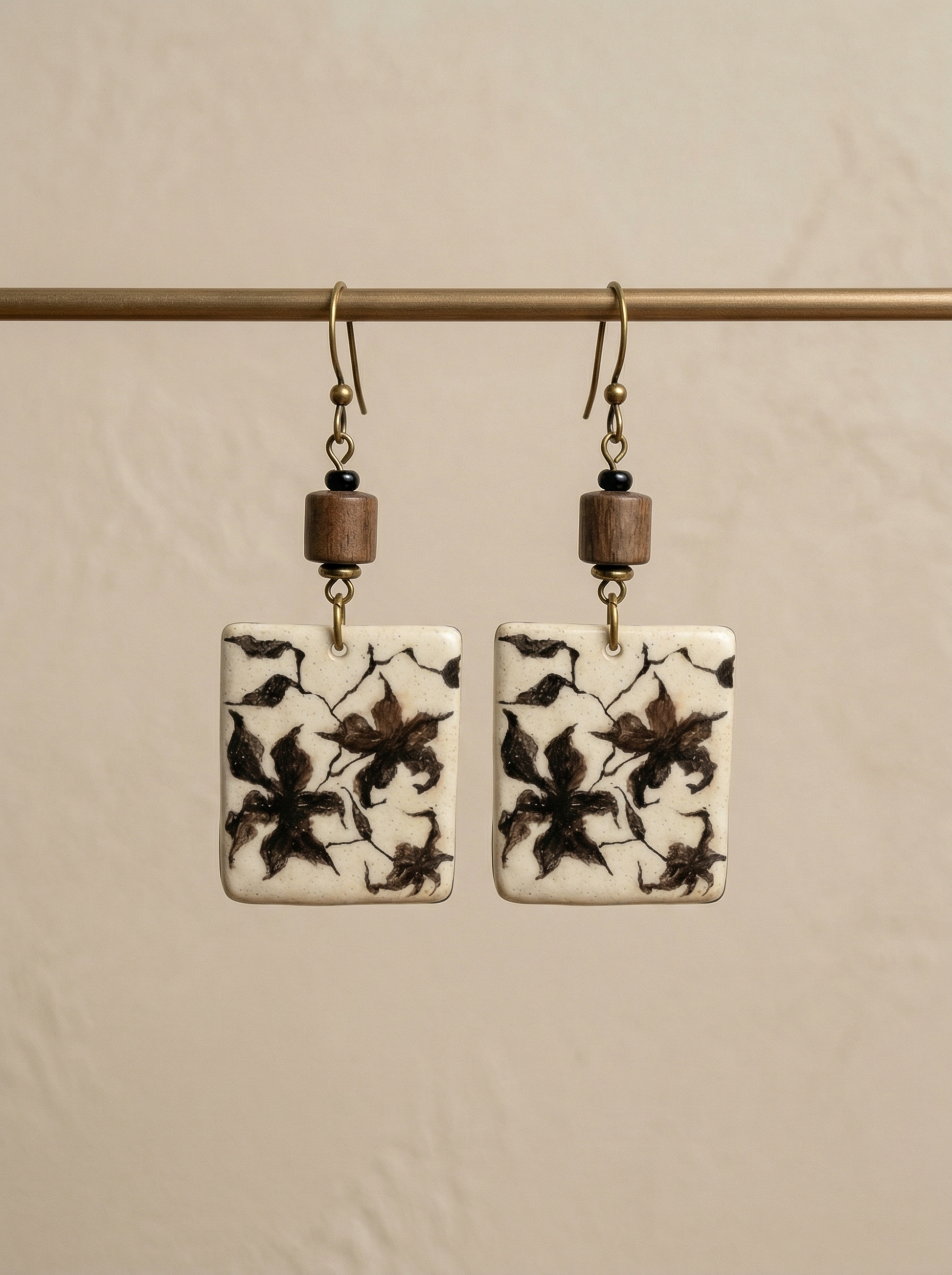 A pair of HECROWN rectangular ceramic earrings featuring hand-painted botanical patterns and rustic wooden beads. Authentic Jingdezhen handmade jewelry with a vintage artisan touch.