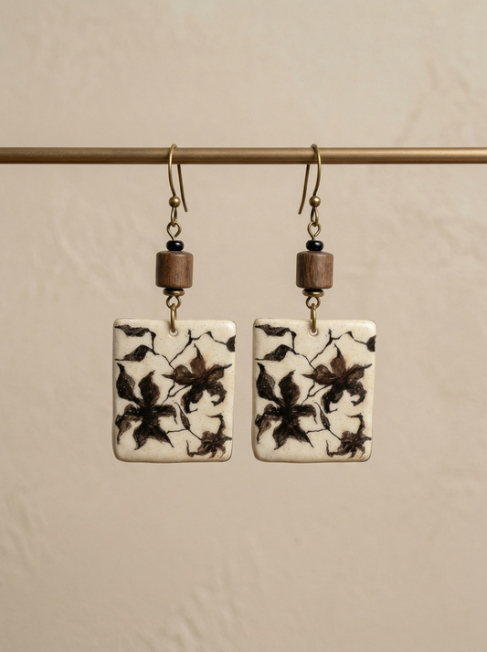 A pair of HECROWN rectangular ceramic earrings featuring hand-painted botanical patterns and rustic wooden beads. Authentic Jingdezhen handmade jewelry with a vintage artisan touch.