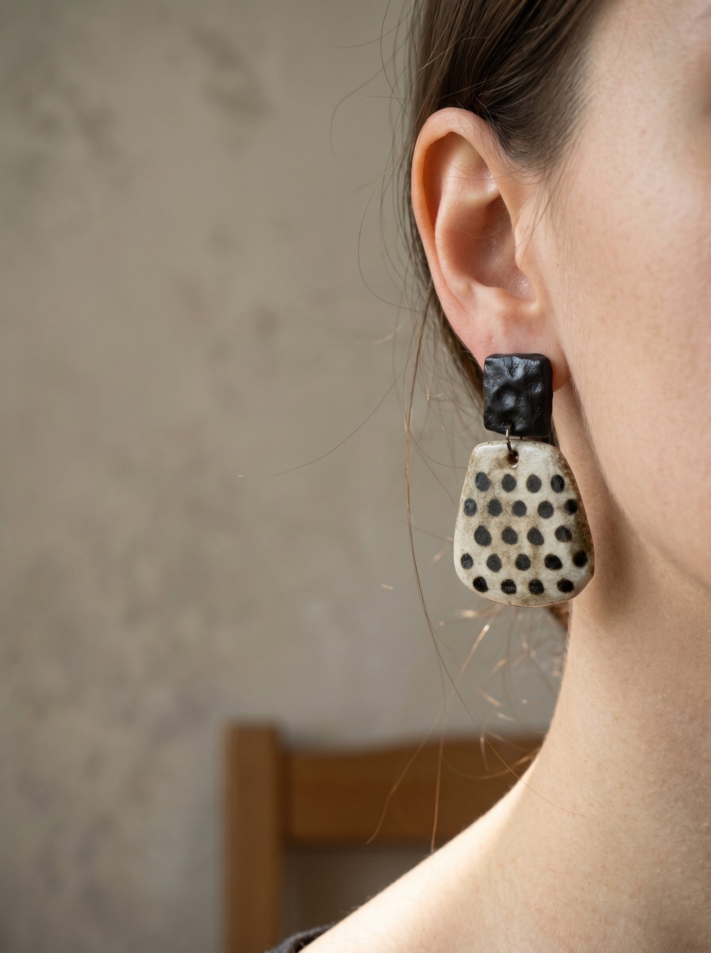 Model wearing HECROWN chunky black and white speckled ceramic statement earrings. A bold piece of wearable art highlighting sincere Jingdezhen craftsmanship.